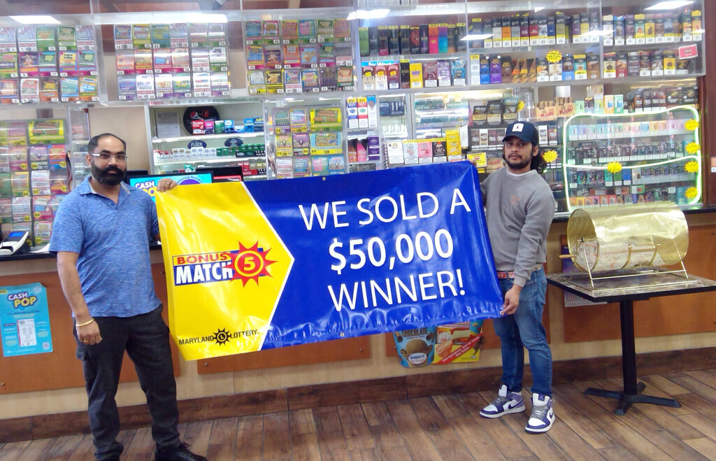 owner and employee holding banner